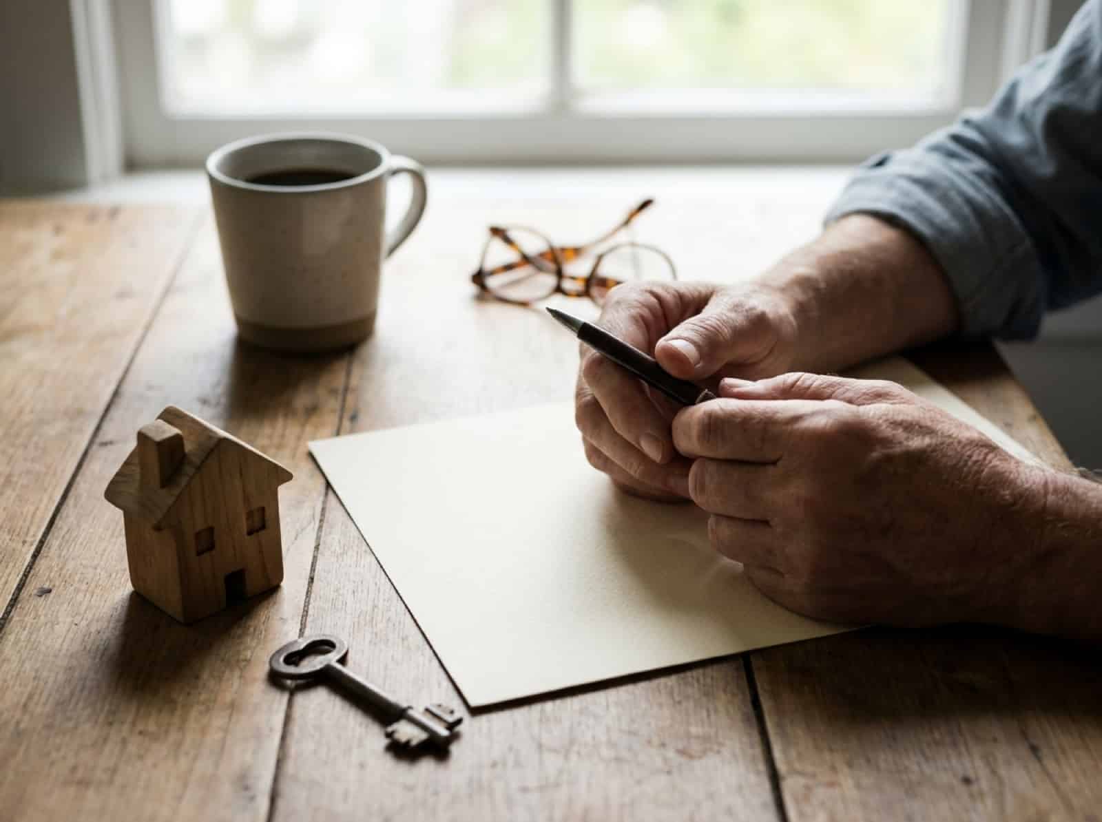 Hausbesitzer prüft am Küchentisch die Unterlagen zur Gebäudeversicherung