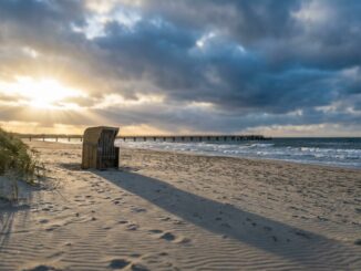 Leerer Sandstrand an der Ostsee im Herbst mit Strandkorb und Wolkenhimmel