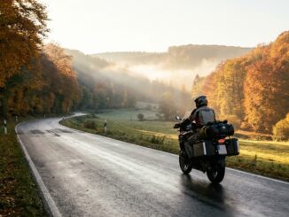 Motorradfahrer auf einer kurvigen Landstraße bei einer Motorradtour im Herbst